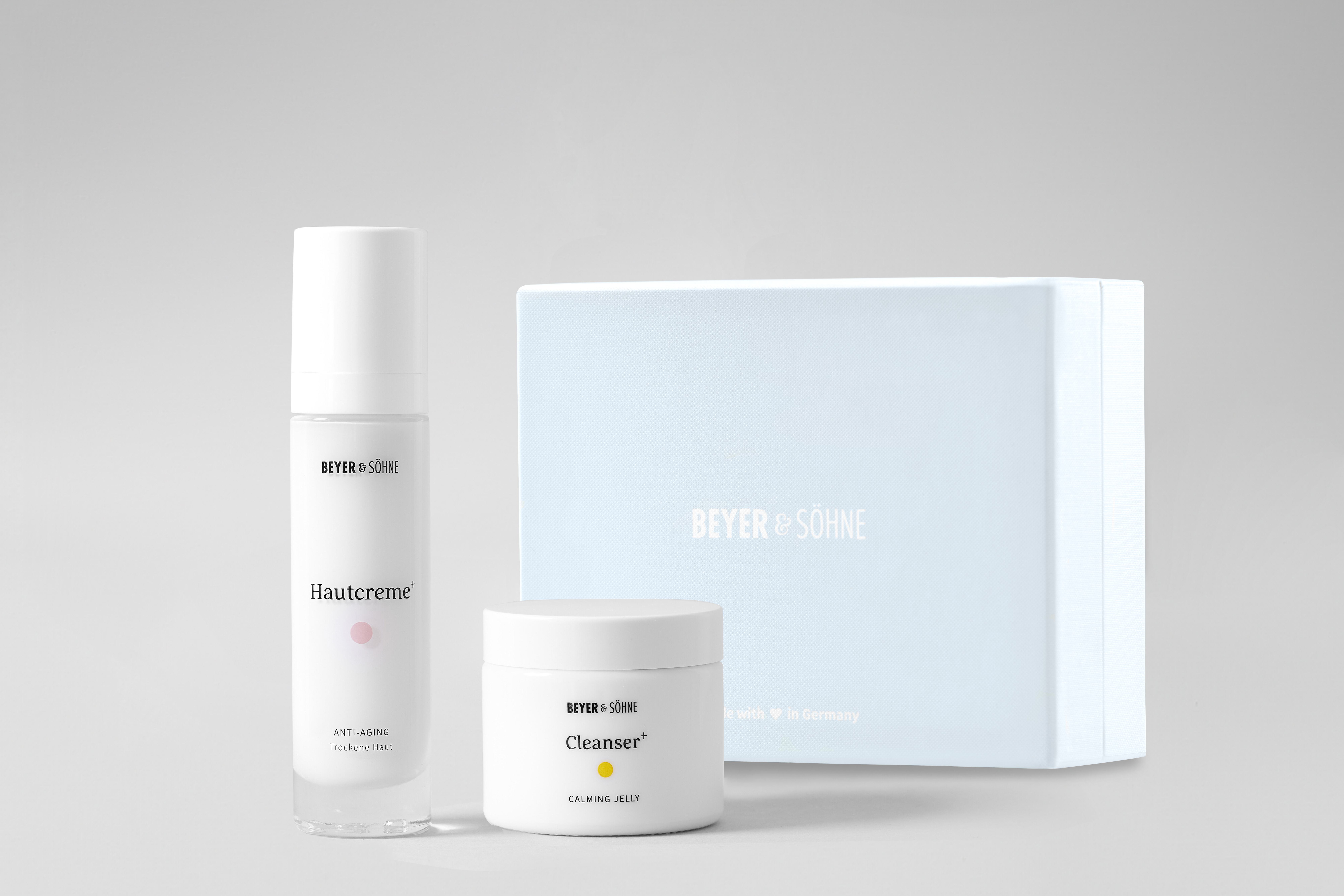 Hautcreme für trockene Haut und Cleanser von Beyer & Söhne in hochwertige, Glasspender und Tiegel vor hellblauer Geschenkbox